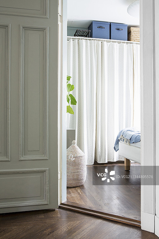透过卧室敞开的门看窗帘后的衣柜图片素材