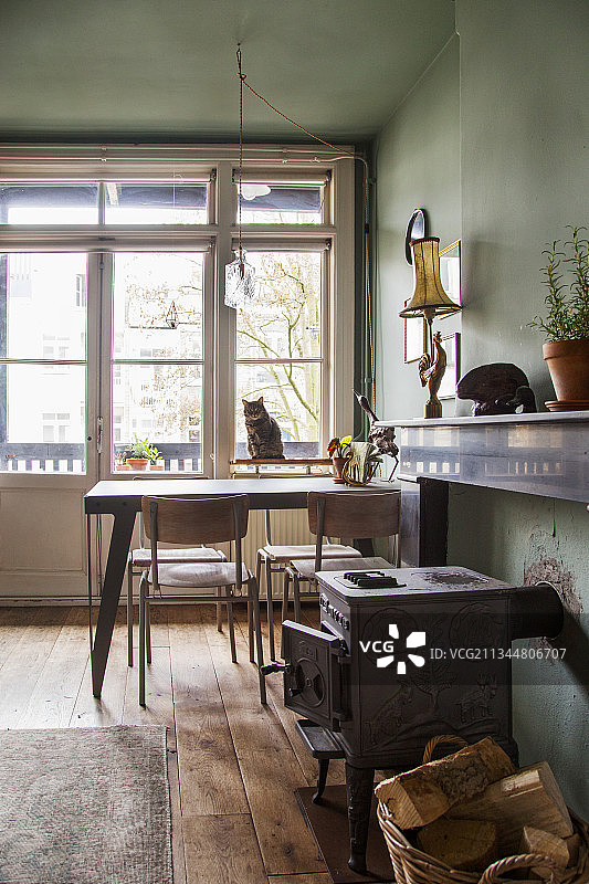 窗前装有燃烧器和用餐区，猫坐在窗台上图片素材