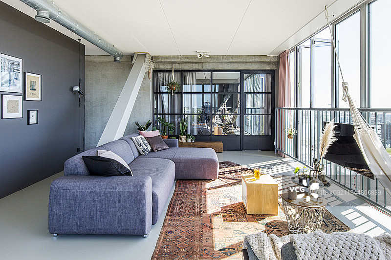 带折叠玻璃墙的客厅中的灰色沙发图片素材