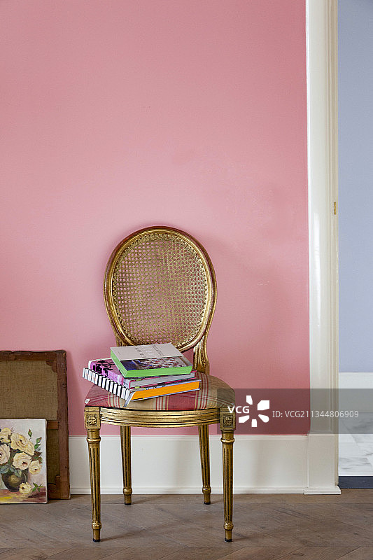 粉色墙壁前的镀金圆形椅图片素材