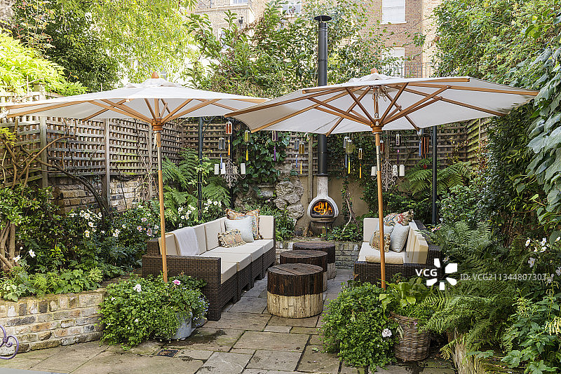舒适庭院花园中的遮阳伞、烟囱和休闲家具图片素材