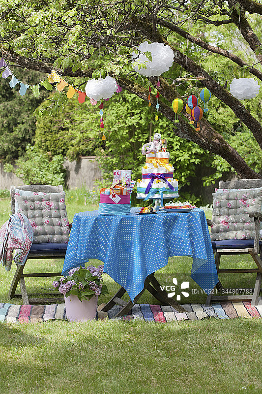婴儿送礼派对上带有尿布蛋糕和花环的彩色桌子图片素材