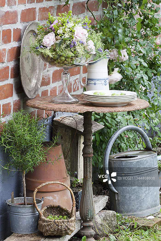 玻璃高脚杯和锌桶中迷迭香的玫瑰花摆放图片素材
