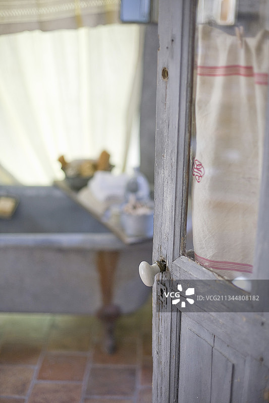 一扇带有窗户和铜绿的敞开的门,可通往怀旧的浴室图片素材