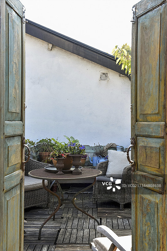 透过风化的双开门看复古风格的屋顶露台图片素材