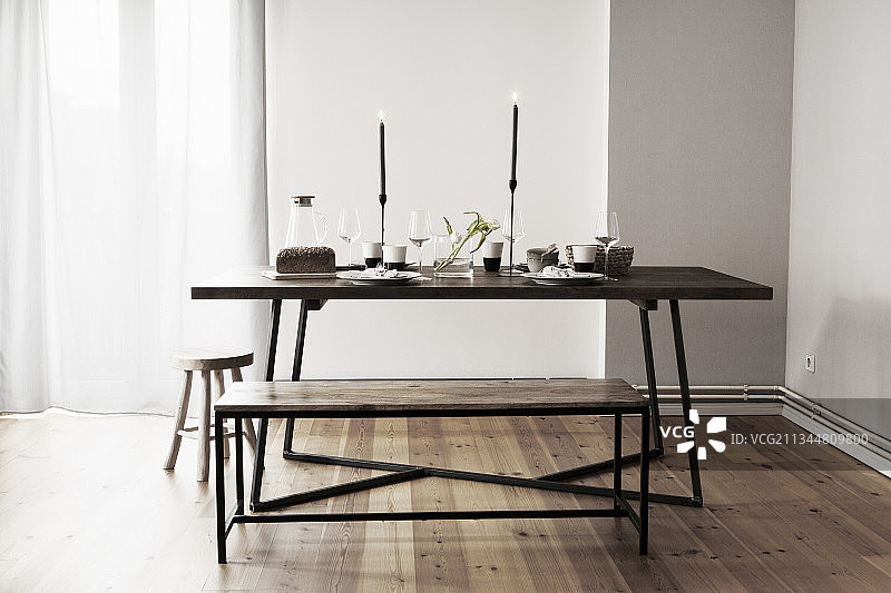 带蜡烛、长椅和凳子的餐桌布置图片素材