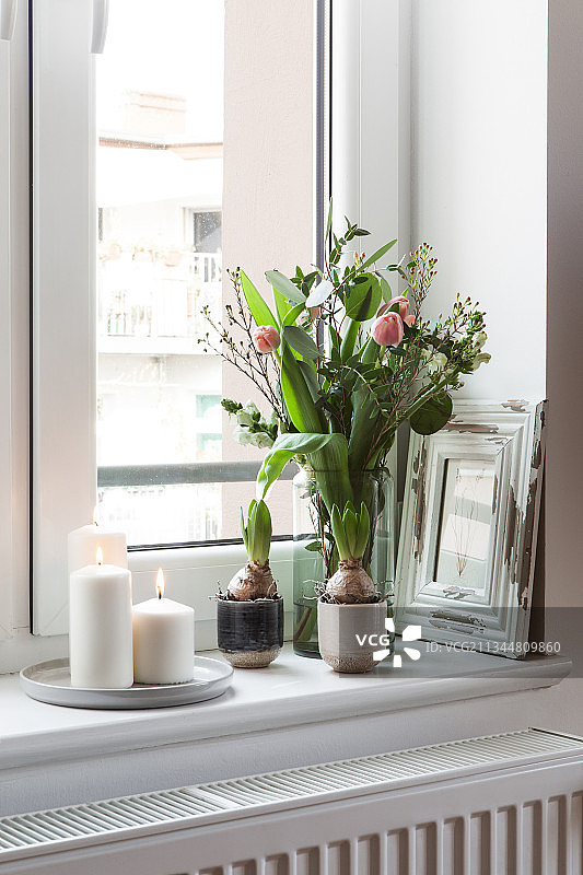 窗台上的郁金香和白色蜡烛春季花束图片素材