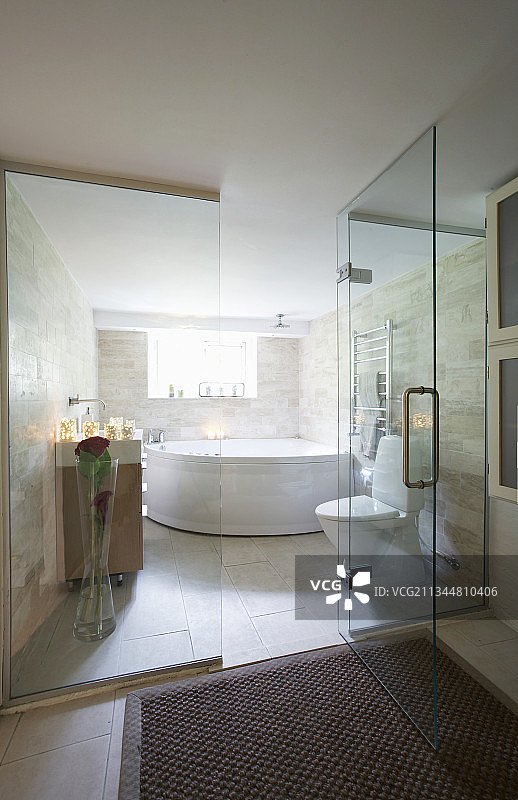 浴室玻璃墙后的转角浴缸图片素材