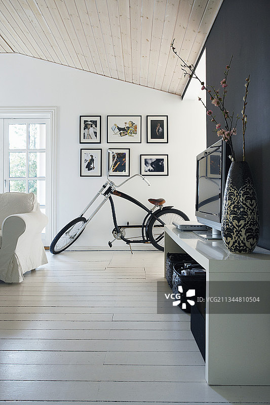 客厅里的电视柜和自行车，配有白板地面和黑色装饰墙图片素材