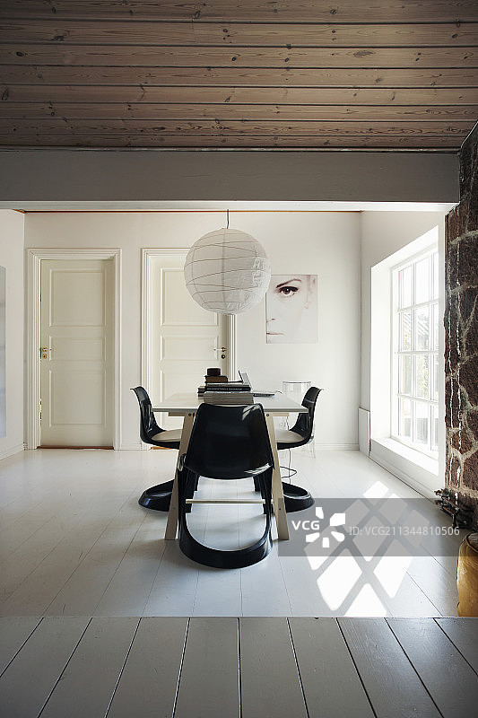 格子窗旁的餐桌和设计师椅图片素材