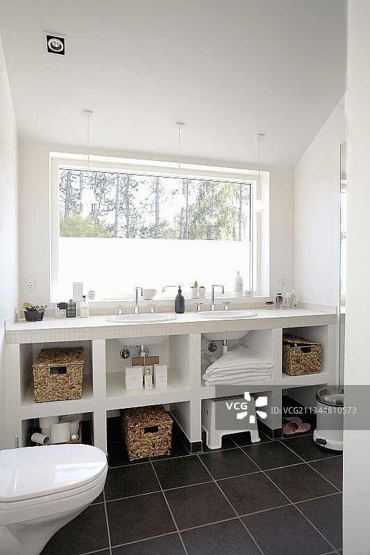 浴室窗户下的白色盥洗台与置物架图片素材