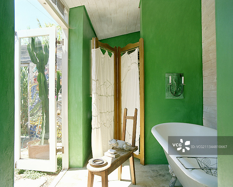 带绿色墙壁和露台的浴室中的独立式浴缸和屏风图片素材