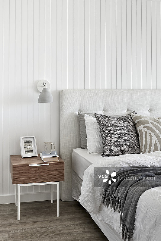 卧室里的床和床头柜，白色墙壁图片素材