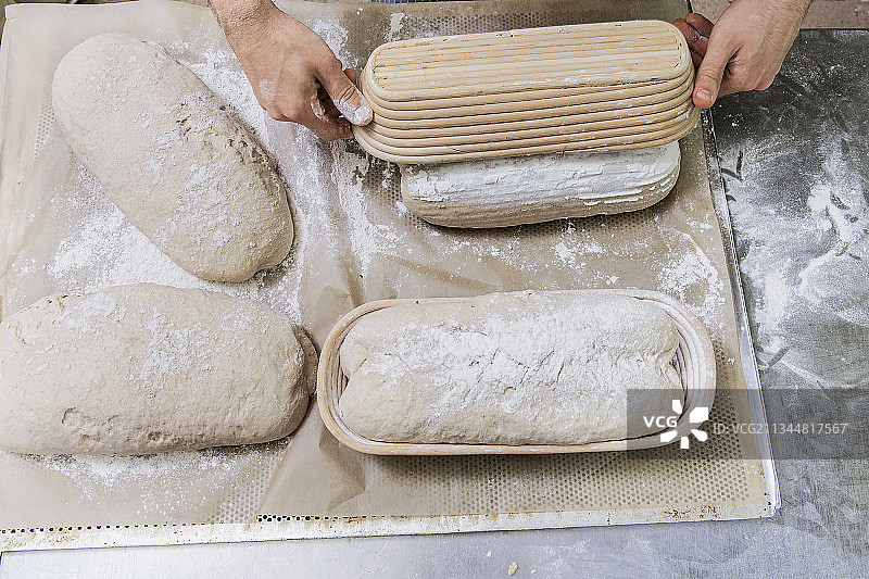 棕色面包制作过程：从发酵篮中取出面团放在托盘上图片素材