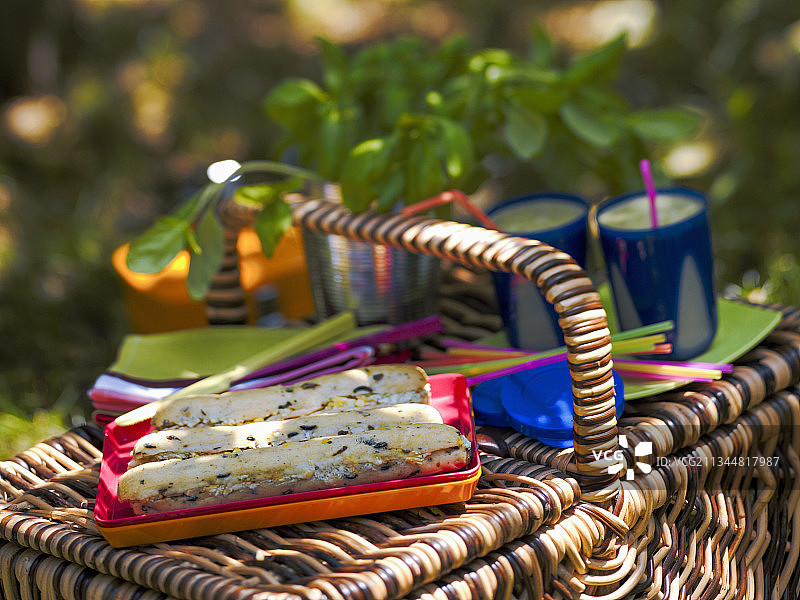 野餐篮上的金枪鱼三明治和冰沙图片素材