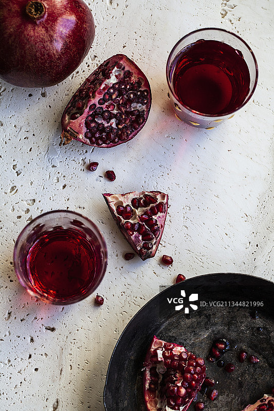 完整和切半的石榴与石榴汁图片素材