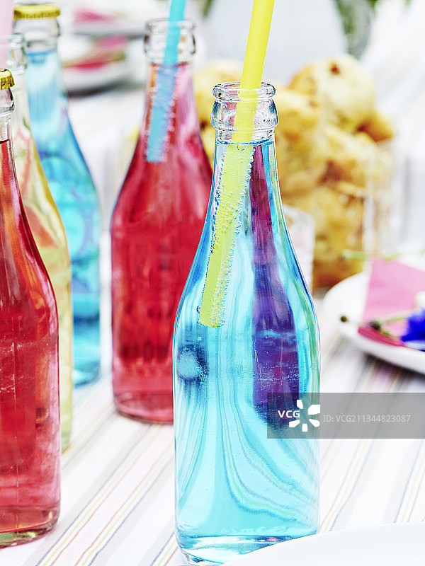 带气泡水和吸管的彩色玻璃瓶图片素材