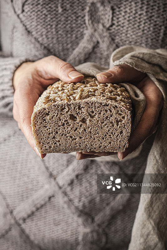 女人手拿着一个无麸质面包图片素材