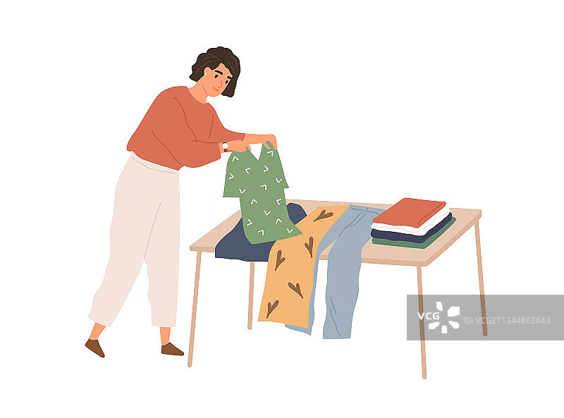 女人折叠旧衣服并挑选图片素材