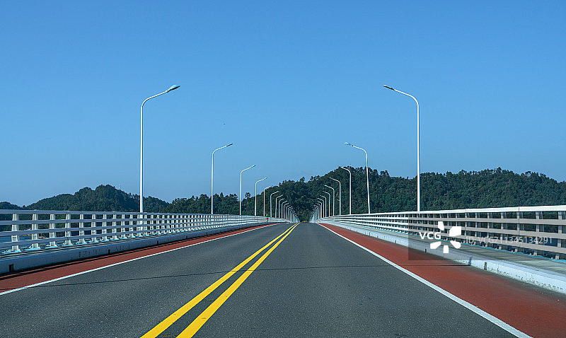 一段笔直的高速公路桥梁和黄色的汽车行道线图片素材