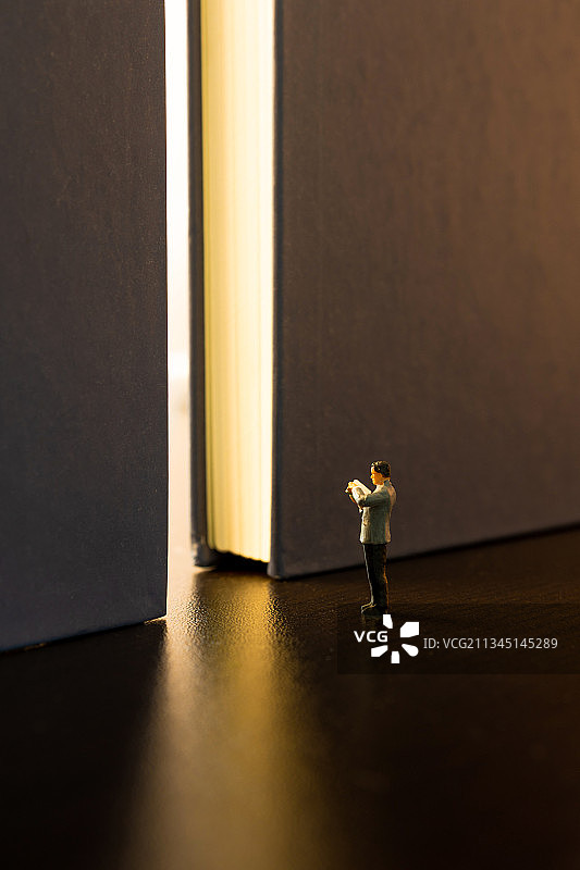 微缩景观读书青年在书籍的大门前图片素材