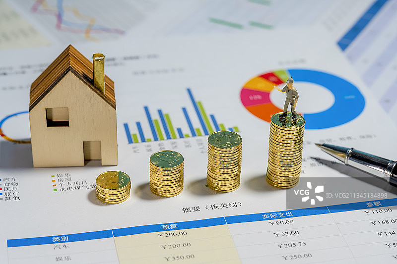 桌面上放着的金币与小房子金融主体场景图片素材