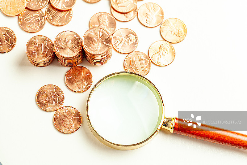 金融概念静物硬币放大镜特写图片素材