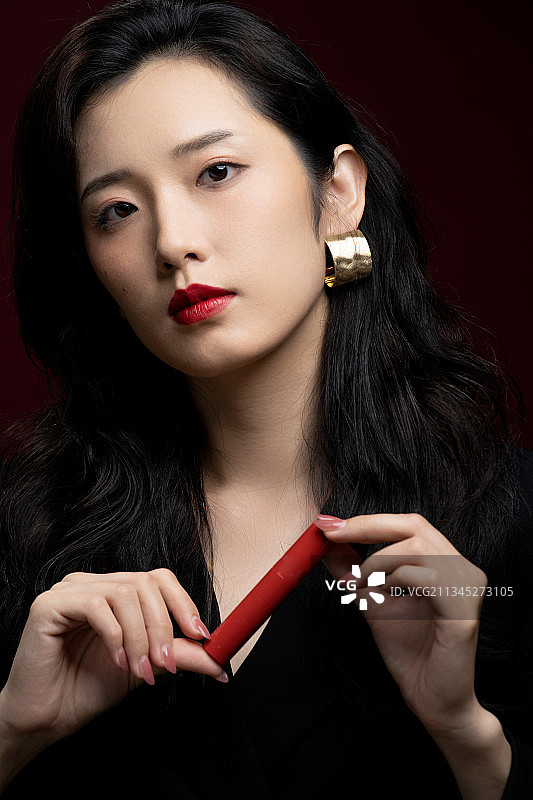 时尚青年女性拿着唇彩产品图片素材