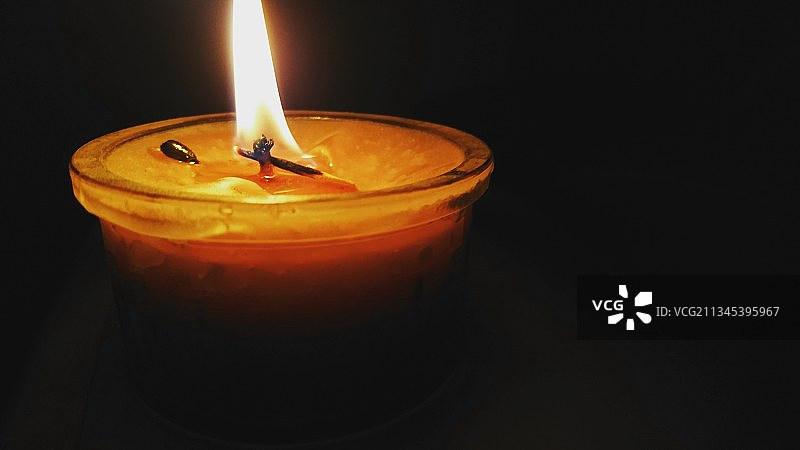 暗室中点燃的蜡烛的特写图片素材