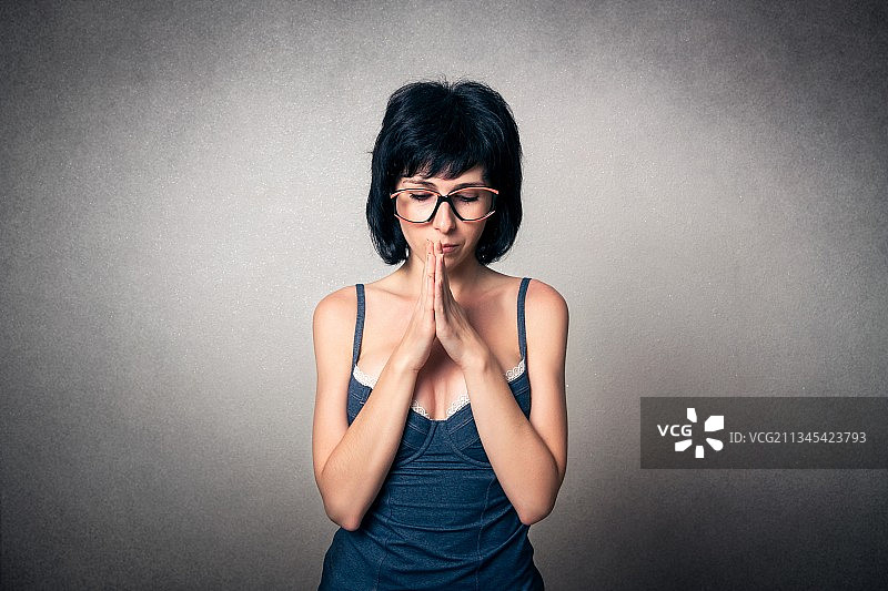 在灰色背景下手势的年轻女人 портрет图片素材