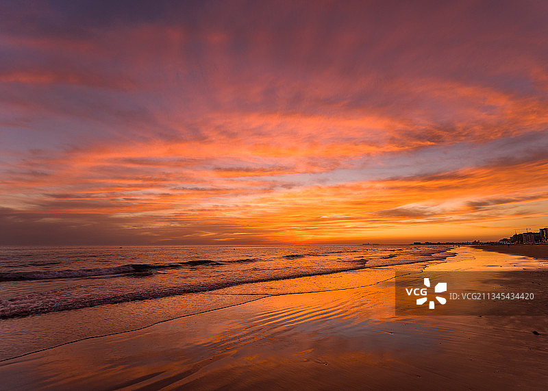 日落时，天空映衬下的海滩风景图片素材