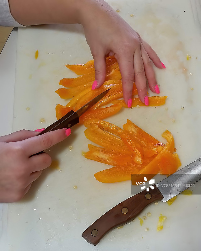 在砧板上用刀切割的手部特写图片素材