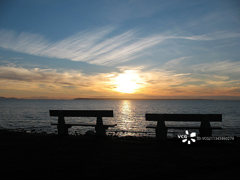 日落时分，加拿大不列颠哥伦比亚省白石镇海滩上的长椅轮廓图片素材