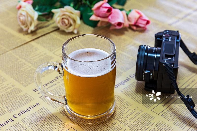 放在桌上的一杯啤酒和小相机图片素材