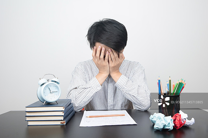 亚洲男性在书桌前学习读书思考图片素材