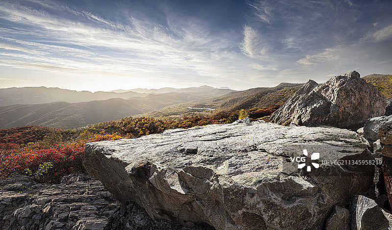 黄昏阳光下的山峰和巨石平台，秋天户外美景图片素材