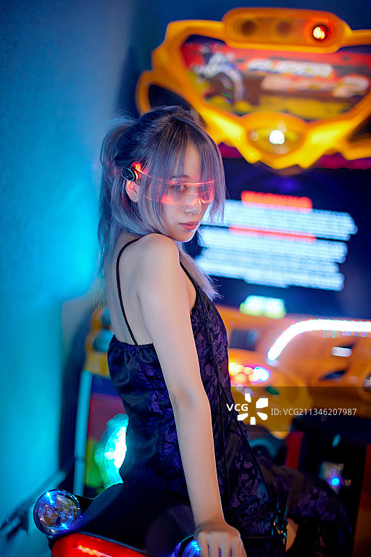 在电子游戏娱乐城玩耍的亚洲时尚少女图片素材