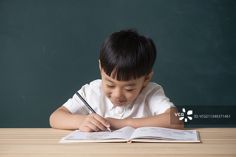 小男孩在黑板前学习图片素材