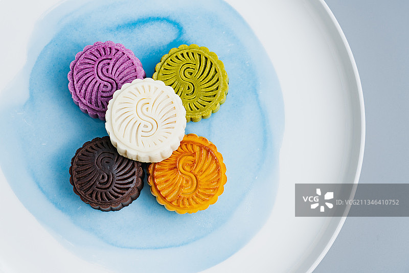 彩色的中秋月饼放在白色盘子中图片素材