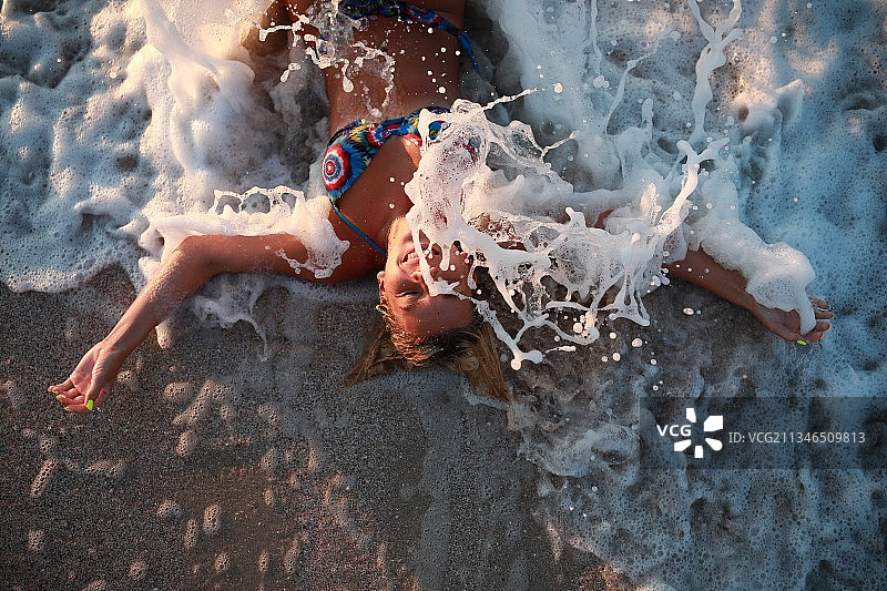 年轻女人躺在沙滩上图片素材