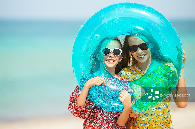 快乐有趣的女孩们在热带海滩玩耍图片素材
