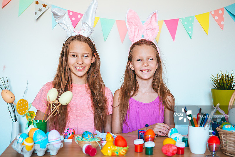 姐妹在家拿着复活节彩蛋的微笑画像图片素材