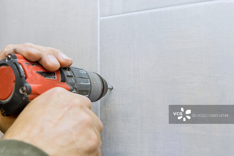 在浴室墙壁的瓷砖上钻孔特写图片素材