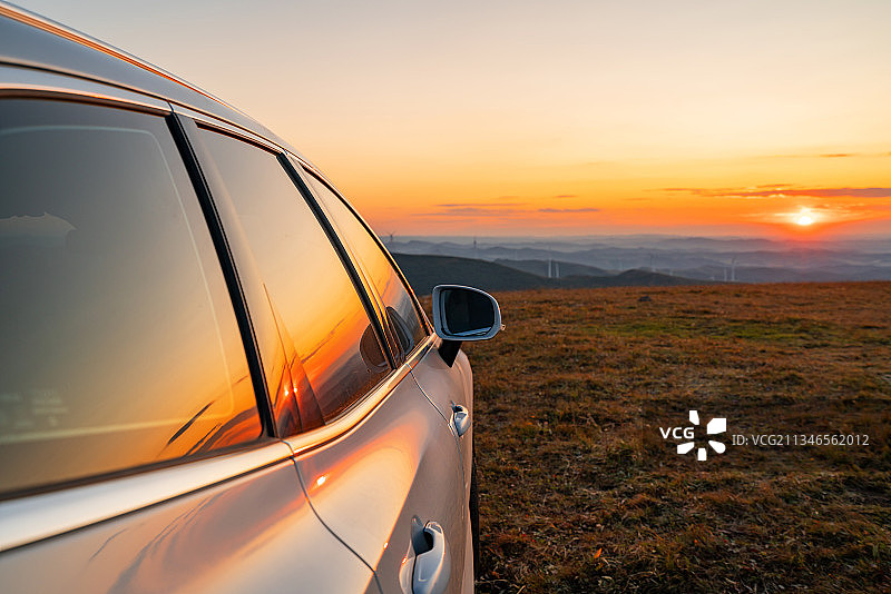 草原山顶观日落照在汽车上的余晖图片素材