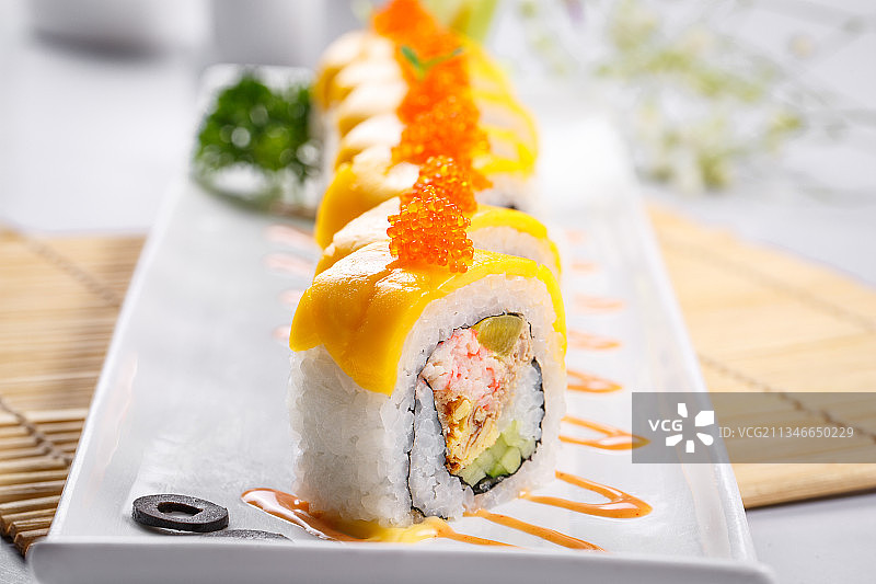 黄金甲蟹子寿司卷摆放在寿司帘上图片素材