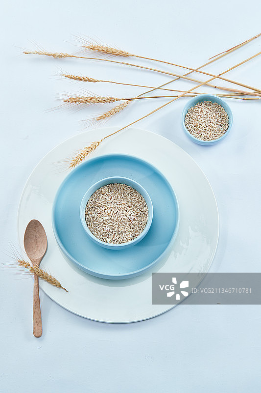 白色背景上的青蓝瓷器皿装的燕麦米（莜麦）图片素材