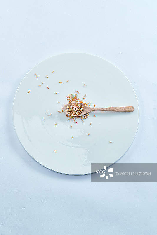 白色背景上的青蓝瓷器皿装的燕麦米（莜麦）图片素材