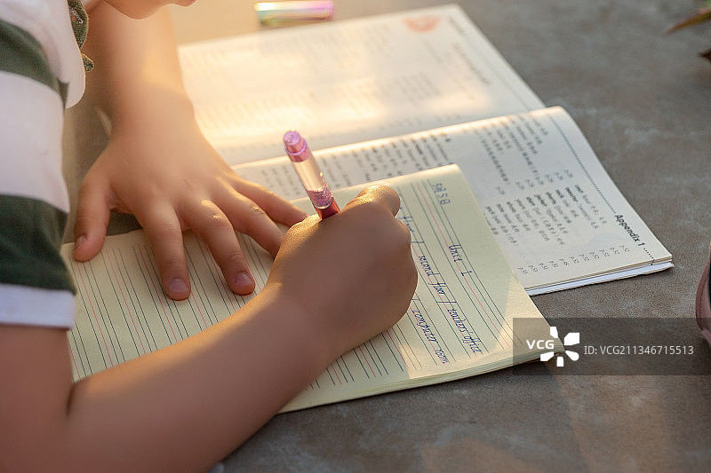 小学生趴在路边石桌上写作业图片素材