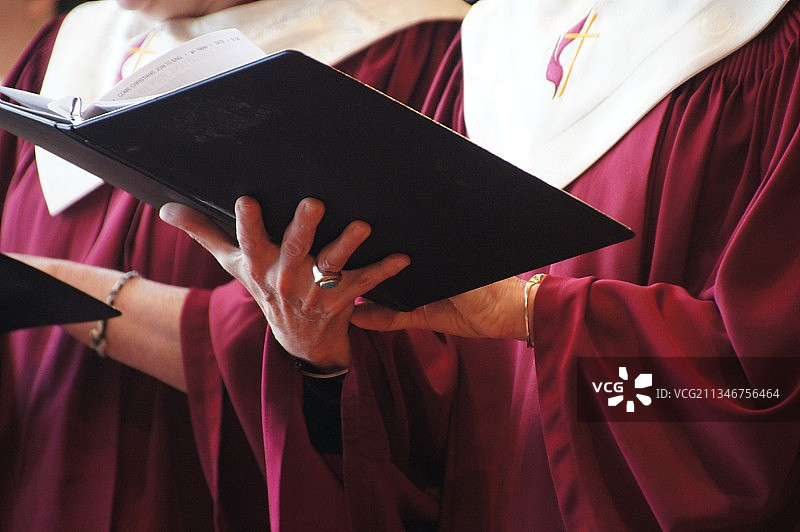 身穿毕业礼服阅读书籍的女子图片素材