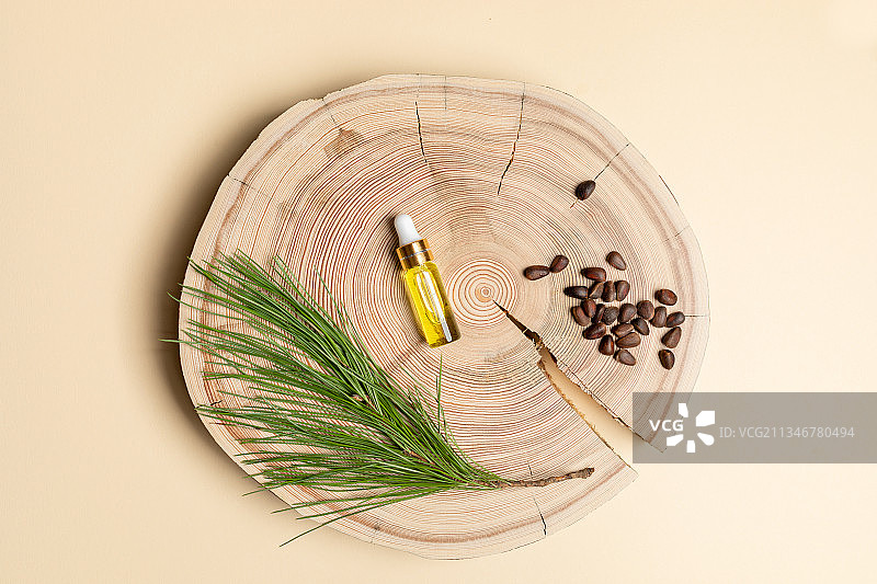 雪松精油玻璃瓶、树枝和木板上的坚果图片素材